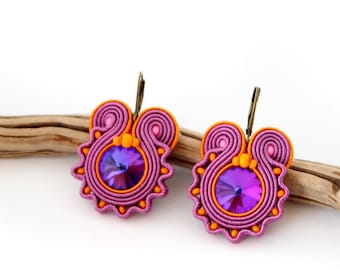May include: A pair of pink and orange earrings with a purple rhinestone in the center of each earring.
