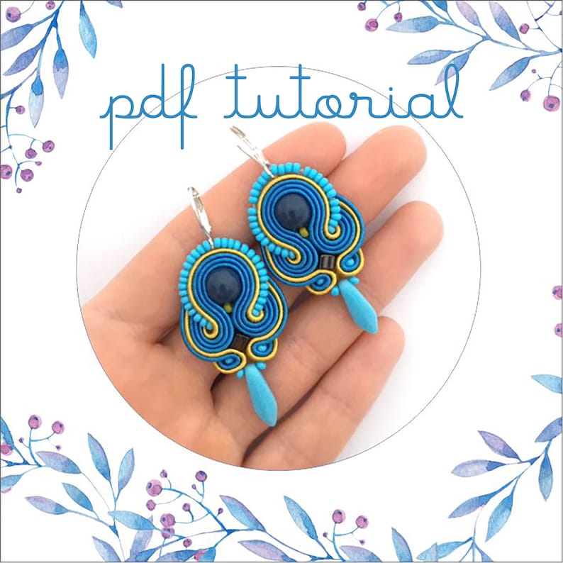 Pode incluir: Um par de brincos azuis e dourados com uma conta azul escura no centro. Os brincos s&atilde;o feitos com uma t&eacute;cnica chamada ponto peyote. Os brincos est&atilde;o pendurados em ganchos prateados. A imagem inclui o texto "pdf tutorial".