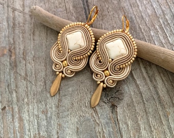 Brincos de soutache em tons de areia, bege e marrom-areia, brincos pendentes off-white, brincos dourados e bege.