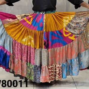 May include: A vibrant, patchwork skirt with a tiered design. The skirt features a variety of colorful fabrics, including pink, blue, orange, and gold, with intricate patterns. The text "PW80011" is visible at the bottom of the image.