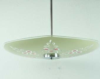 Może przedstawiać: Zielona szklana lampa sufitowa z białym i czerwonym wzorem kwiatowym. Lampa ma chromowane wykończenie i okrągły baldachim.