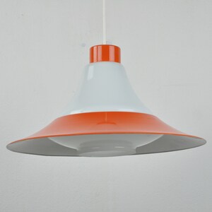 May include: A white and orange pendant light with a wide, bell-shaped shade.