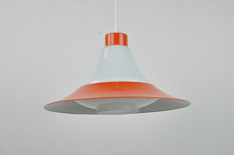 May include: A white and orange pendant light with a wide, bell-shaped shade.
