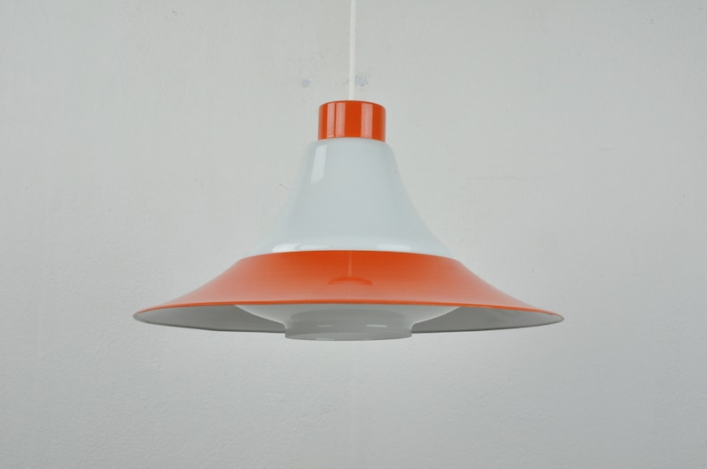 May include: A white and orange pendant light with a wide, rounded, bowl-shaped shade.