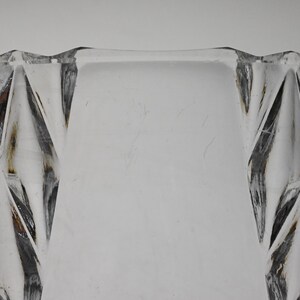 May include: Close-up of the top edge of a clear glass bowl with a diamond-shaped pattern.