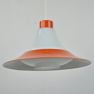May include: A white and orange pendant light with a wide, flared shade. The shade is white on the inside and orange on the outside.
