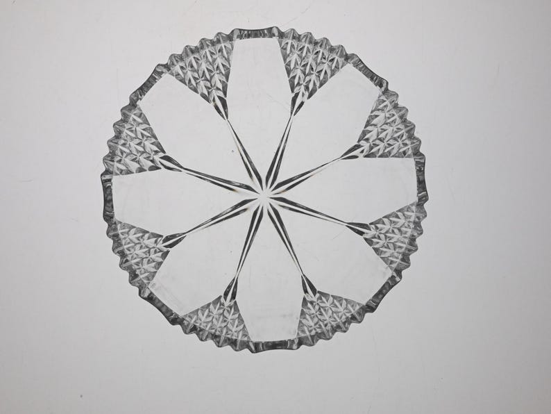 May include: A clear glass plate with a starburst design. The plate has a scalloped edge and is perfect for serving desserts or appetizers.