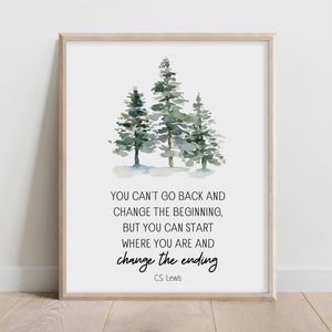 Könnte beinhalten: Ein gerahmter Druck mit einer Aquarellillustration von drei immergrünen Bäumen in Grün- und Grautönen. Der Druck enthält das Zitat "YOU CAN'T GO BACK AND CHANGE THE BEGINNING, BUT YOU CAN START WHERE YOU ARE AND change the ending" von C.S. Lewis.