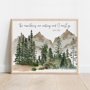 May include: A framed watercolor print featuring a mountain landscape with evergreen trees and the quote "The mountains are calling and I must go" by John Muir. The artwork has a natural, earthy color palette.