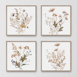 Può includere: Set di quattro stampe quadrate con illustrazioni ad acquerello di fiori secchi e fogliame in tonalità di marrone, beige e bianco su uno sfondo bianco.