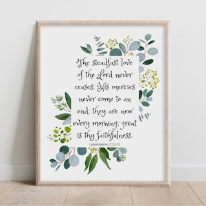 Op de afbeelding: Ingelijste print met de tekst "De bestendige liefde van de Heer houdt nooit op; zijn barmhartigheid kent geen einde, ze is elke morgen nieuw; groot is uw trouw." Bloemen versieren de rand.