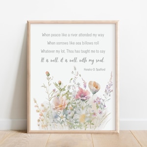 May include: A framed print featuring a watercolor floral design in soft pinks, peaches, and purples. The print includes the text of a poem by Horatio G. Spafford, with the words "It is well, it is well, with my soul."