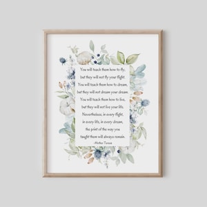 May include: Framed art print featuring a quote by Mother Teresa surrounded by watercolor floral elements in shades of blue, green, and white. The quote is centered on a white background, and the frame is a light wood color.