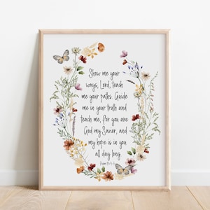 May include: A framed wall art print featuring a watercolor floral wreath surrounding the text: Show me your ways, Lord, teach me your paths. Guide me in your truth and teach me, for you are God my Savior, and my hope is in you all day long. Psalm 25:4-5.