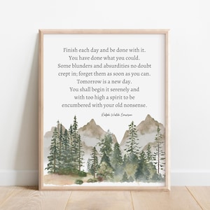 Op de afbeelding: Een printbare quote van Ralph Waldo Emerson over het fris beginnen van elke dag. De quote is geplaatst tegen een aquarel achtergrond van een mistig bos met groene bomen en bruine bergen.