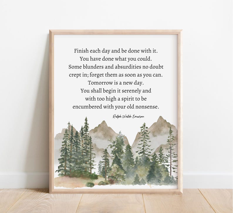 Op de afbeelding: Een printbare quote van Ralph Waldo Emerson over het fris beginnen van elke dag. De quote is geplaatst tegen een aquarel achtergrond van een mistig bos met groene bomen en bruine bergen.