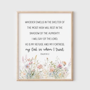 May include: A framed print with a floral watercolour design at the bottom and a religious quote in black text. The quote reads, "Whoever dwells in the shelter of the Most High will rest in the shadow of the Almighty." Psalm 91:1-2.