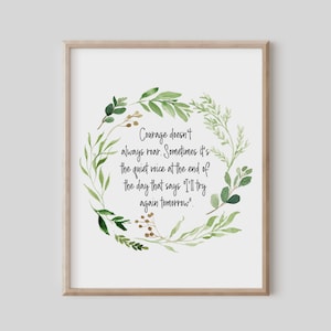 Pode incluir: Uma impressão emoldurada com uma moldura de madeira clara. A impressão apresenta uma coroa de aquarela de folhas verdes e a citação: "A coragem nem sempre ruge. Às vezes é a voz silenciosa no final do dia que diz 'Tentarei novamente amanhã.'"