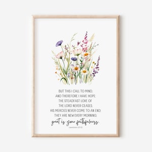 Könnte beinhalten: Ein gerahmter Druck mit einer Aquarellillustration von Wildblumen in Lila, Rosa und Gelb. Das Kunstwerk enthält ein Zitat aus Klagelieder 3:21-23 mit den Worten "great is your faithfulness" in handschriftlicher Schrift.