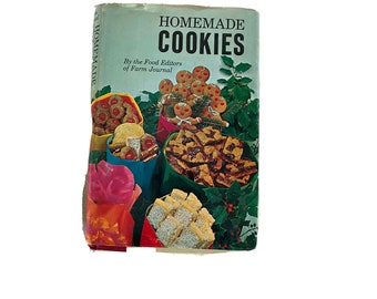 Könnte beinhalten: Ein Vintage-Kochbuch mit dem Titel "Homemade Cookies" von den Food Editors des Farm Journal. Das Cover zeigt verschiedene Kekse in bunten Papiertüten, darunter Lebkuchenmänner und Kirschkekse, vor einem grünen Hintergrund.