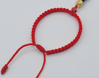 Puede incluir: Pulsera de cuerda roja con un dije de mano negra y una cuenta azul de ojo turco.