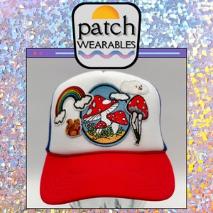 Pode incluir: Um boné de caminhoneiro branco e vermelho com um remendo de cogumelos bordados, um esquilo, um arco-íris e uma nuvem. O boné tem o texto "patch wearables" na frente.