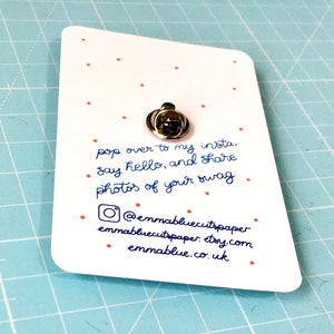 May include: A white card with red dots and blue text. The text reads "pop over to my insta. &bull; say hello, and share photos of your swag" and includes the social media handle "@emmabluecutspaper", website "emmabluecutspaper.etsy.com", and website "emmablue.co.uk".