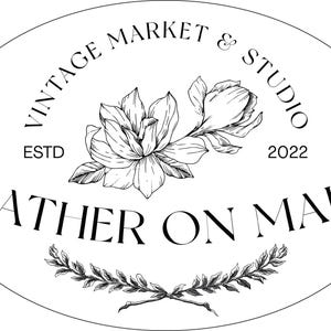 May include: Oval logo with the text "Vintage Market & Studio" and "Gather on Main". A floral illustration is in the center, with the year "2022" and "ESTD" visible. The design is in black and white.