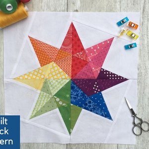 May include: A colorful quilt block pattern with a star design. The star is made up of 12 triangles in various colors, including red, orange, yellow, green, blue, and purple. The background is white.