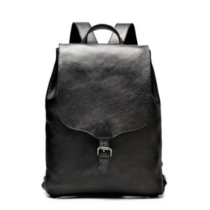 Black leather backpack with a flap closure and buckle detail, featuring a top handle and adjustable straps. The design is sleek and sophisticated, classic black backpack, cowhide leather backpack, genuine leather backpack, large backpack, back to school gift, gift for him, birthday gift