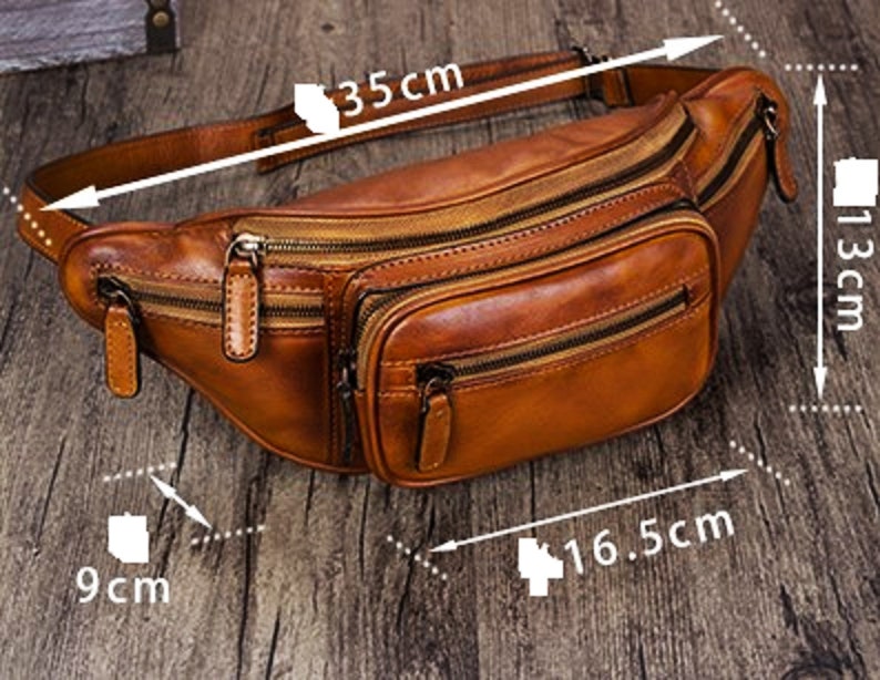 May include: A brown leather fanny pack with multiple zippered compartments. The pack measures 35 inches in length, 13 inches in height, and 16.5 inches in width.