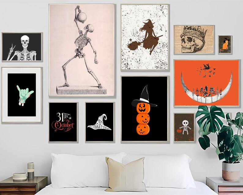 May include: A gallery wall featuring various Halloween-themed art prints. The collection includes a skeleton, a witch on a broom, a skull with a crown, and stacked jack-o'-lanterns. The color palette includes black, orange, white, and brown.