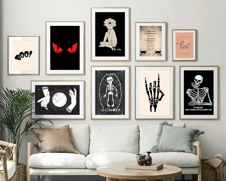 May include: A collection of framed art prints with a Halloween and gothic theme. The prints feature images of a skeleton, a hand making a rock on gesture, and the word "boo!". Other prints include a figure with a flower head and a pair of red eyes.