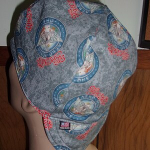 May include: A gray and blue welding cap with a repeating pattern of a blue circle with a white eagle and the words "Aero Force One" in red. The cap has a small American flag label that says "Made in USA".