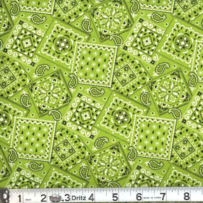 May include: Green fabric with a repeating pattern of white and black paisley and bandana designs.