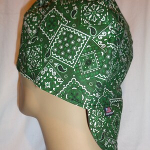 May include: Green bandana-style welding cap with a white paisley pattern. The cap has a long flap that covers the neck and shoulders. Made in the USA.