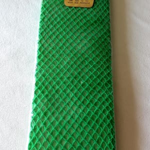 May include: Bright green knee socks in a diamond net pattern, packaged in clear plastic. The label reads "KNEE SOCKS" and "S-T-R-E-T-C-H". The text also states "ONE SIZE TO FIT YOUR SIZE PERFECTLY".