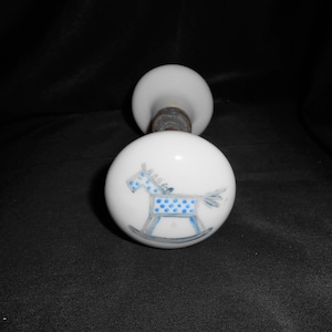 Puede incluir: Pomo de puerta de porcelana blanca con un diseño de caballo de balancín azul y blanco.
