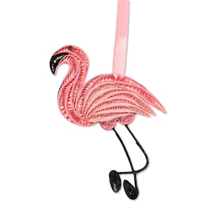 May include: A pink flamingo ornament crafted from coiled paper strips, known as quilling. The flamingo features a black beak, long black wire legs, and a light pink satin ribbon loop at the top for hanging. The body displays intricate paper swirls.