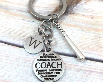 May include: Silver keychain with a baseball bat charm and a round tag that says "Coach" with the words "Focused, Responsible, Energetic, Skilled, Positive, Inspiring, Supportive, Fun, Charismatic, Strong" around it. There is also a smaller round tag with the letter "W" on it.