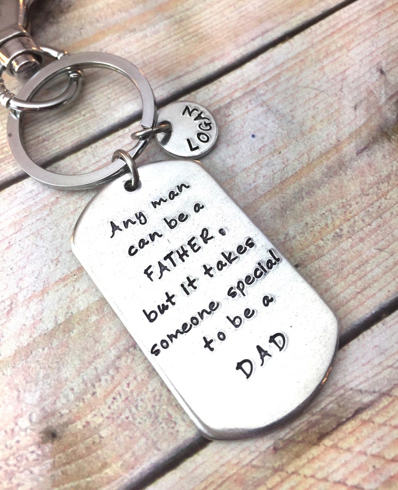May include: Silver keychain with a tag that reads "Any man can be a FATHER, but it takes someone special to be a DAD".