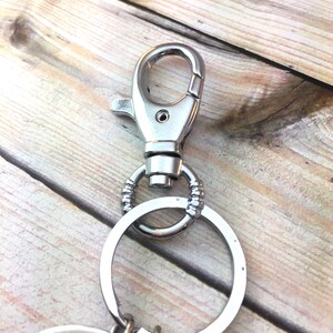 May include: Silver key chain with a large ring and a lobster clasp.