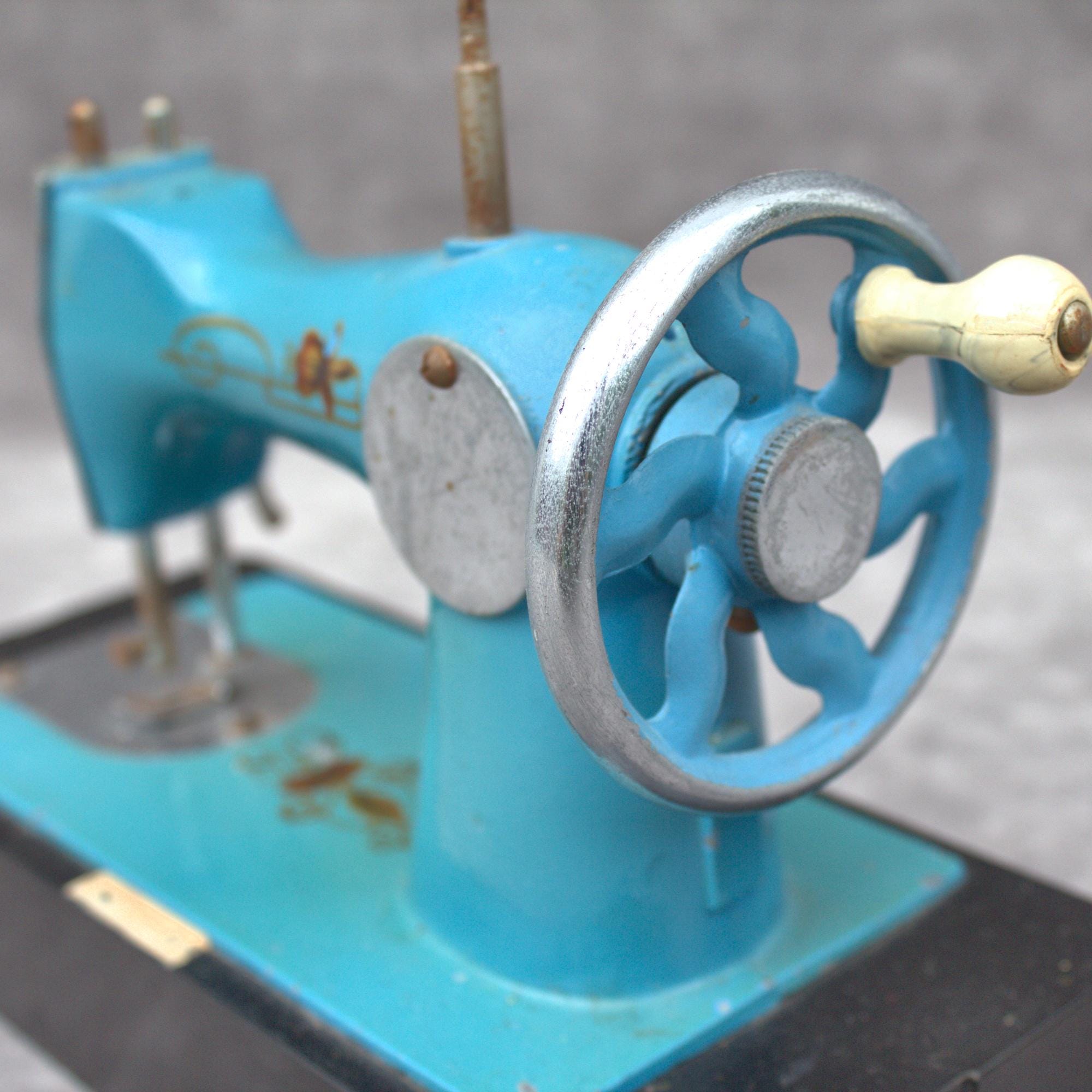 本物のヴィンテージ金属製子供用ミシン、ライトブルー。装飾的な花柄が