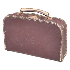 May include: A rectangular brown suitcase featuring a top handle, a metal latch closure, and visible white stitching along the edges. The exterior surface shows signs of wear with light scuffs and scratches across the dark brown material.