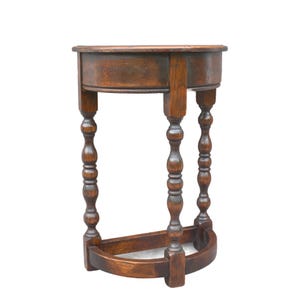 May include: A semi-circular wooden side table featuring a dark brown finish with visible wood grain. The table has a flat top, three vertical legs with a turned spindle design, and a matching semi-circular base stretcher connecting the legs.