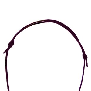 May include: A dark purple cord necklace with a knot at each end.