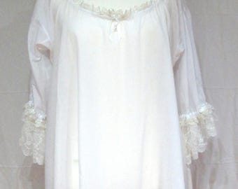 May include: A white nightdress with long sleeves and a round neckline. The nightdress has delicate lace trim around the neckline and cuffs. The garment is displayed on a mannequin.
