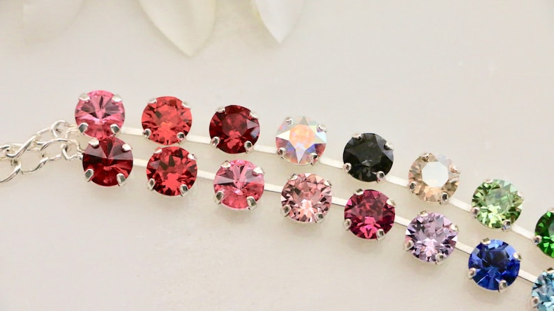 Puede incluir: Una cadena de plata con una fila de cristales de colores. Los cristales est&aacute;n en un degradado de colores, comenzando con el rojo y terminando con el azul.