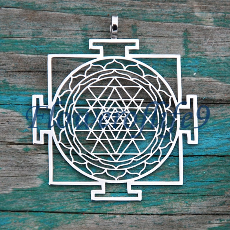 K&ouml;nnte beinhalten: Ein silberner Anh&auml;nger mit einem Sri Yantra, einem heiligen geometrischen Symbol im Hinduismus, mit einem detaillierten Design aus Dreiecken und Kreisen. Der Anh&auml;nger ist ein traditionelles Symbol f&uuml;r Schutz und Wohlstand.