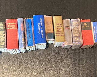 May include: A collection of miniature books with various titles, including "William Shakespeare The Complete Works", "Do Fish Drink Water?", "Favorite Poems Old and New", "English to Spanish Dictionary", "New Lands New Men", "The Death of Shakespeare", "More Wealth Without Risk", and "The Saltry".